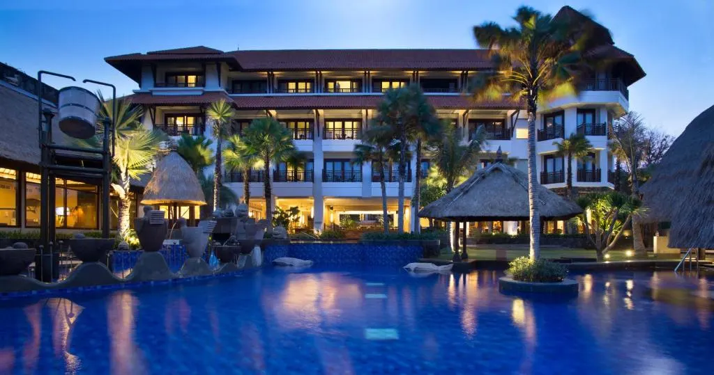 Evening view of Holiday Inn Benoa’s pool and resort building