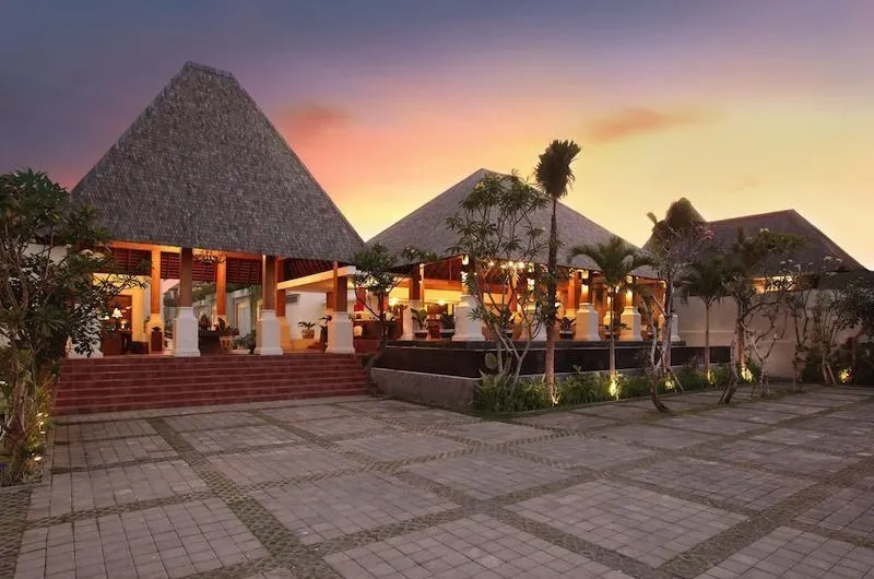 Traditional-style Bali villa with thatched roof at sunset