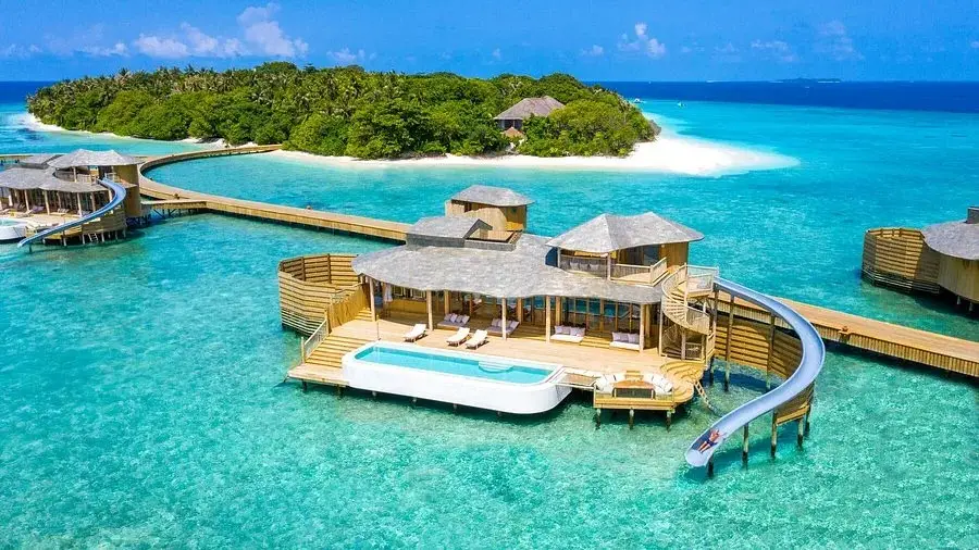 Luxurious overwater villa at Soneva Fushi with waterslide and pool