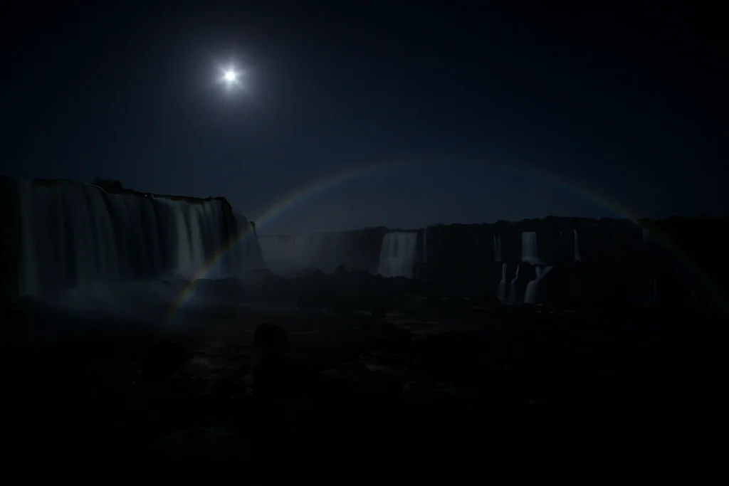 Moonbow forming over Iguazú Falls in Argentina during a full moon night.