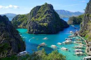 Palawan Coron Lagoon with turquoise waters and boats between limestone cliffs Philippines