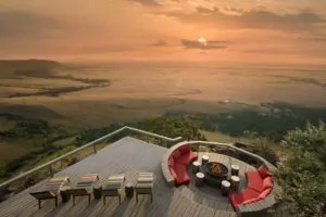 Sunset view from Angama Mara deck overlooking Masai Mara with lounge seating and firepit.